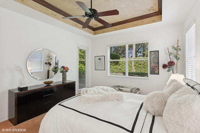 bedroom with ceiling fan, a raised ceiling, and crown molding