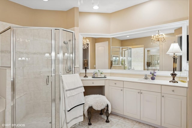 bathroom featuring vanity, an inviting chandelier, tile patterned floors, and a shower with shower door