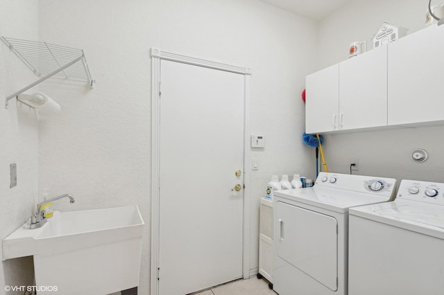 laundry room featuring cabinets, sink, and washing machine and clothes dryer