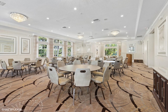 dining area featuring a healthy amount of sunlight, a textured ceiling, and ornamental molding