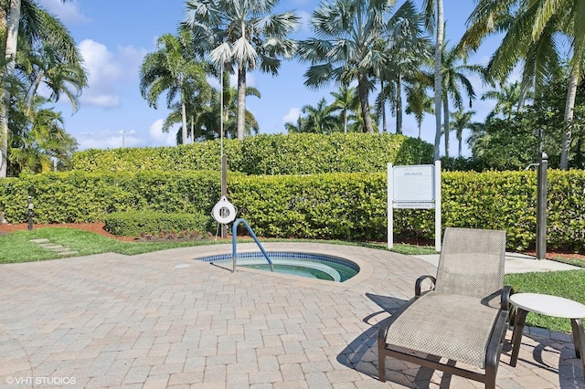 view of swimming pool featuring a patio and a hot tub