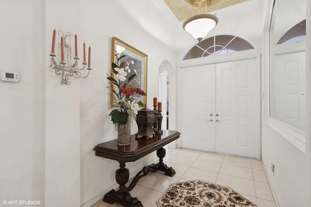 tiled entryway featuring crown molding