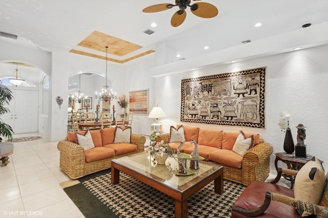 tiled living room featuring ceiling fan with notable chandelier