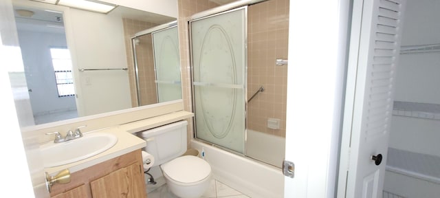 full bathroom featuring tile patterned floors, vanity, toilet, and enclosed tub / shower combo