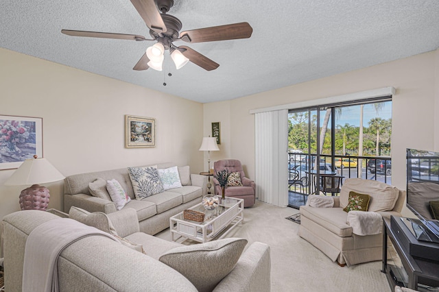 carpeted living room featuring ceiling fan and a textured ceiling