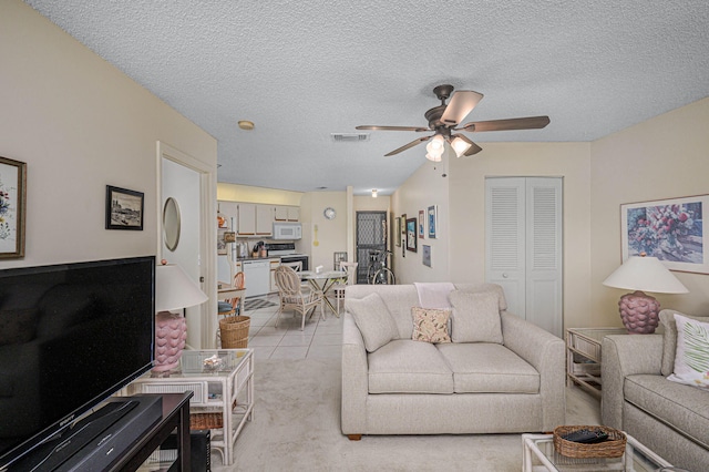 living room with a textured ceiling, ceiling fan, and light carpet