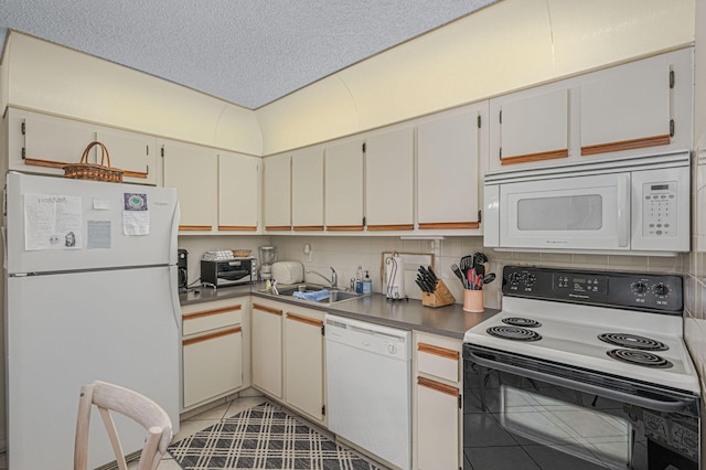 kitchen featuring tasteful backsplash, white cabinetry, sink, and white appliances