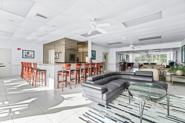 living room featuring light tile patterned floors and a paneled ceiling