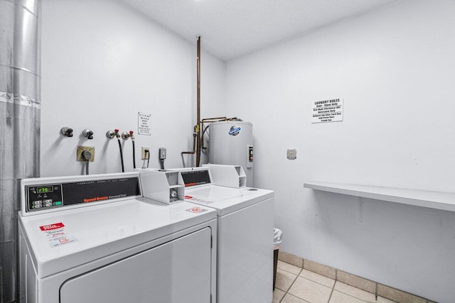 clothes washing area with water heater, light tile patterned flooring, and washer and dryer