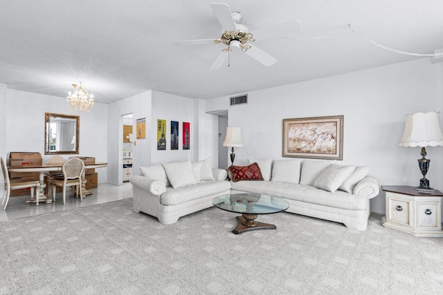 carpeted living room featuring ceiling fan with notable chandelier and a textured ceiling