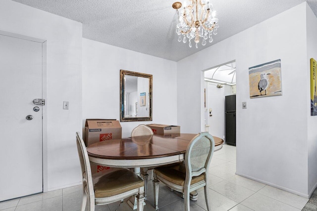 tiled dining room with a textured ceiling and a chandelier