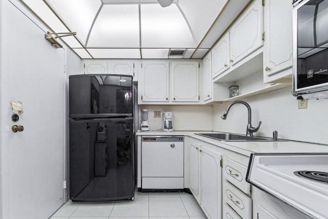 kitchen with white cabinetry, dishwasher, sink, black refrigerator, and light tile patterned floors