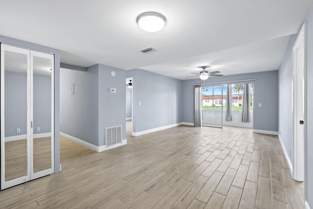 empty room with ceiling fan and light hardwood / wood-style flooring