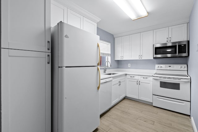 kitchen with white cabinets, white appliances, sink, and light hardwood / wood-style flooring