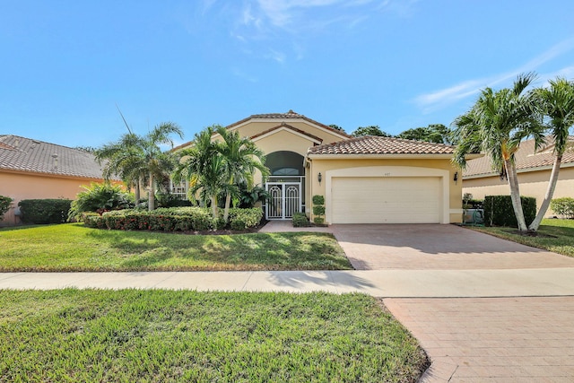 mediterranean / spanish-style house featuring a garage and a front lawn