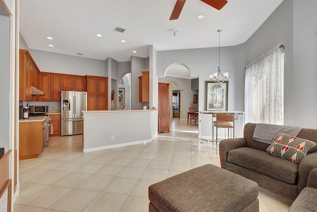 living room with light tile patterned flooring and ceiling fan with notable chandelier