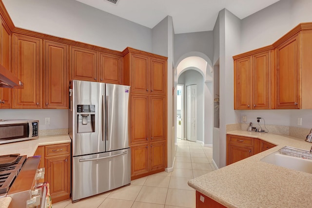 kitchen featuring sink, light tile patterned floors, and stainless steel appliances