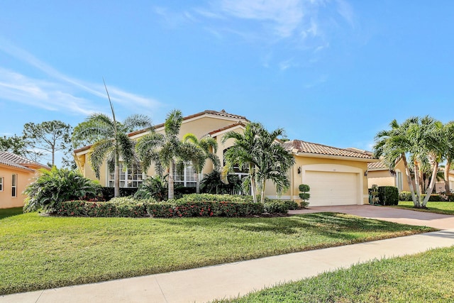 mediterranean / spanish home with a garage and a front yard