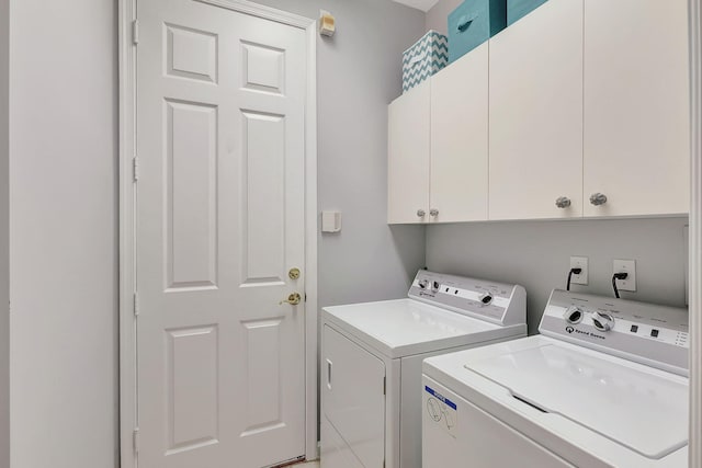 washroom with cabinets and washing machine and clothes dryer