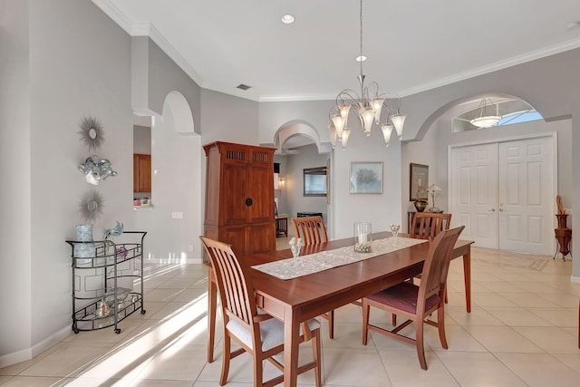 tiled dining space with crown molding and an inviting chandelier