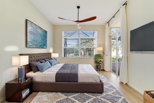 bedroom with access to exterior, light hardwood / wood-style flooring, and ceiling fan