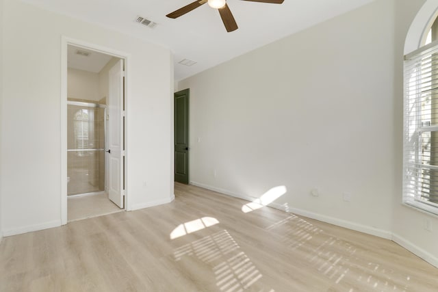 unfurnished bedroom featuring ensuite bath, ceiling fan, and light wood-type flooring