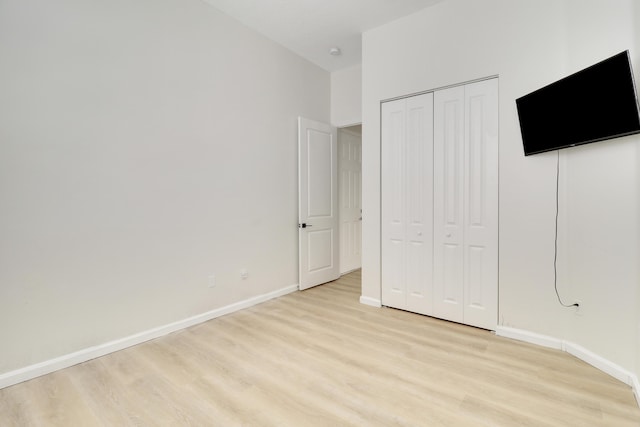 unfurnished bedroom featuring light hardwood / wood-style flooring and a closet