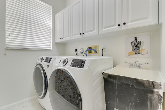 clothes washing area with sink, cabinets, and independent washer and dryer