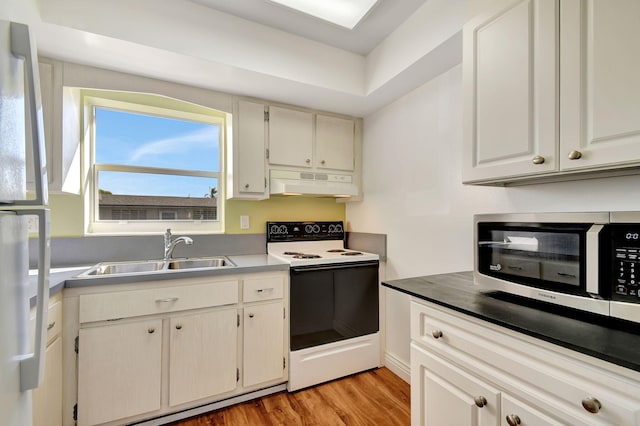 kitchen with white cabinets, white appliances, light hardwood / wood-style flooring, and sink