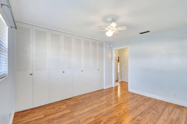 unfurnished bedroom with light wood-type flooring, a closet, and ceiling fan