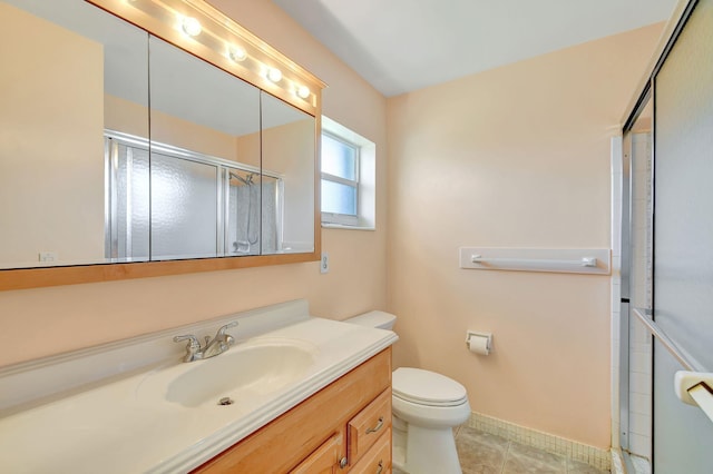 bathroom featuring tile patterned floors, vanity, toilet, and a shower with shower door