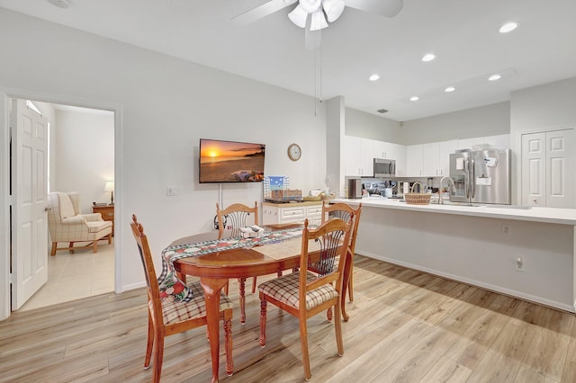 dining space featuring ceiling fan and light wood-type flooring