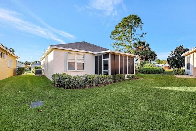 exterior space with a sunroom, a lawn, and central AC