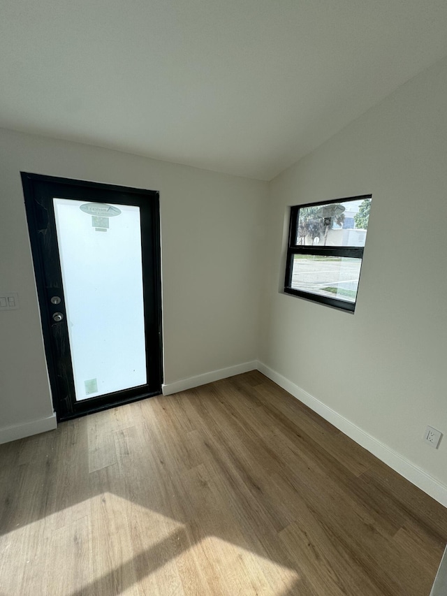 empty room featuring light hardwood / wood-style floors and lofted ceiling