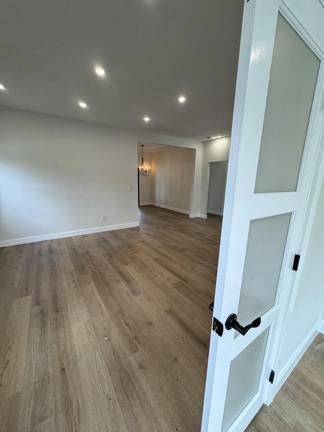 empty room featuring hardwood / wood-style flooring and a notable chandelier