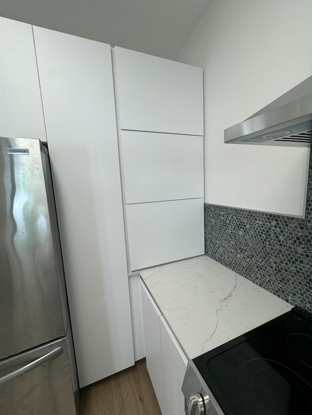 kitchen featuring stainless steel refrigerator, white cabinets, dark hardwood / wood-style floors, and range