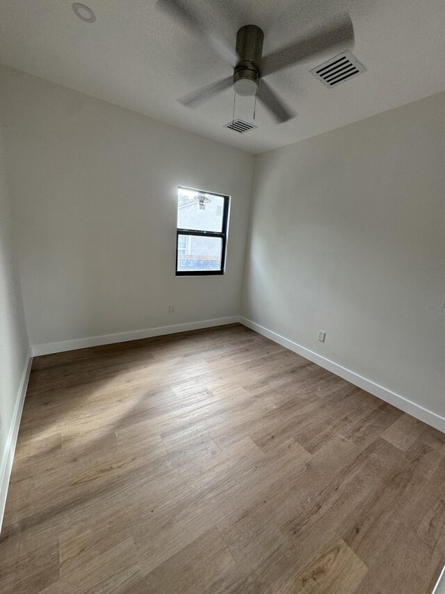 empty room with ceiling fan and light wood-type flooring