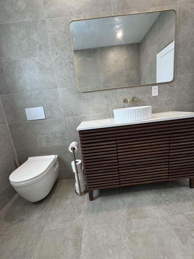 bathroom featuring vanity, toilet, and tile walls