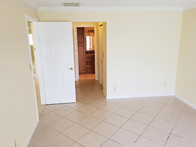 tiled spare room with crown molding