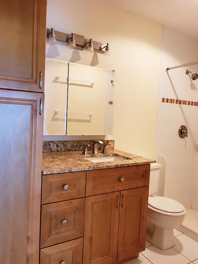 bathroom featuring tile patterned floors, toilet, a shower, and vanity