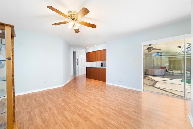 unfurnished living room with light wood-type flooring and ceiling fan