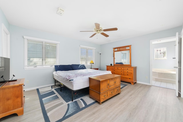 bedroom with ceiling fan, light wood-type flooring, and connected bathroom