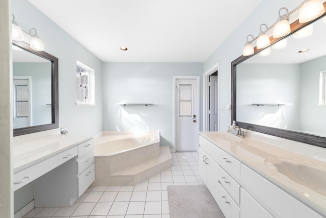 bathroom featuring tile patterned floors, tiled tub, and vanity