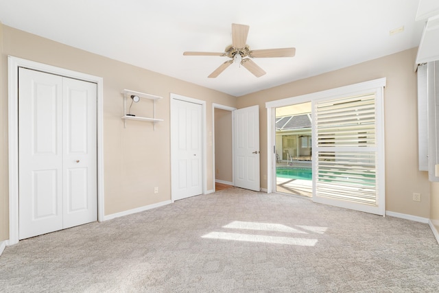 unfurnished bedroom with ceiling fan, light carpet, access to outside, and two closets