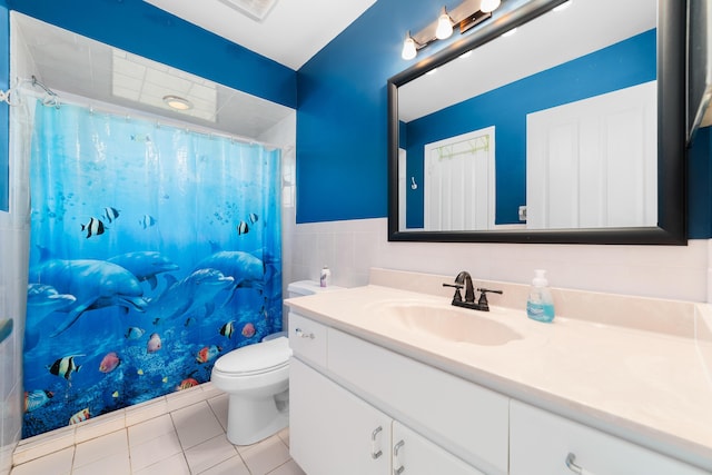 bathroom featuring vanity, tile patterned flooring, toilet, tile walls, and curtained shower