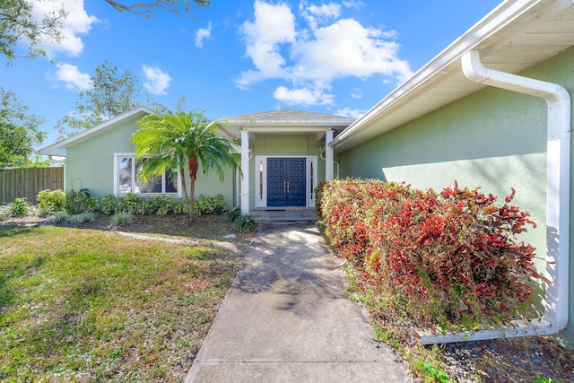 property entrance featuring a lawn