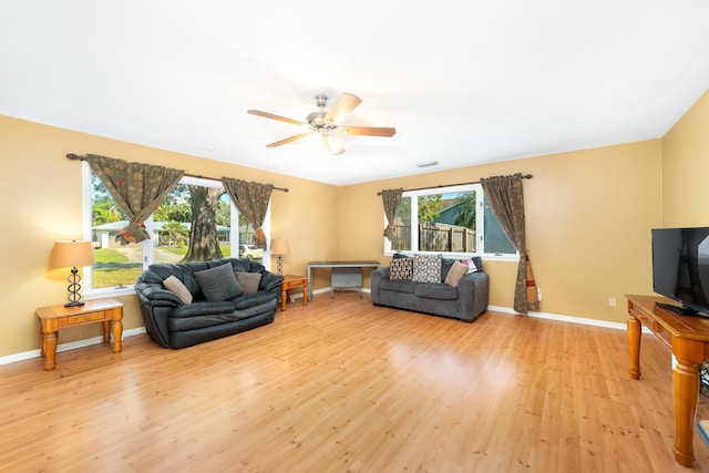 living room featuring plenty of natural light, ceiling fan, and light hardwood / wood-style flooring