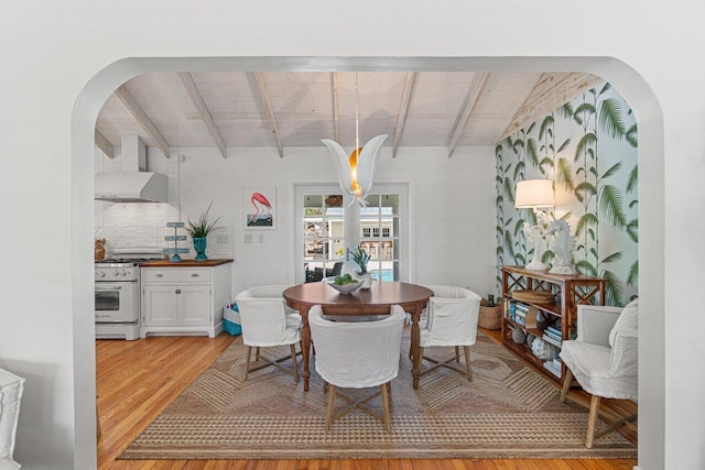 dining room with vaulted ceiling with beams, light hardwood / wood-style floors, wood ceiling, and french doors