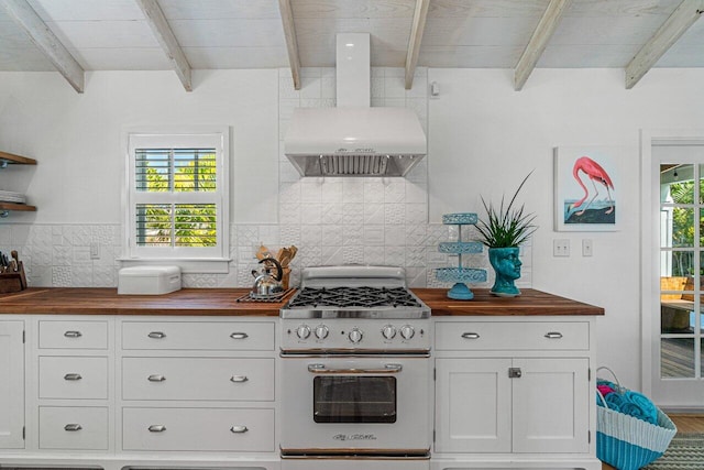 kitchen featuring beam ceiling, wall chimney range hood, wood counters, high end white range oven, and backsplash