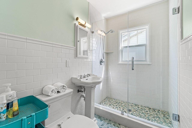 bathroom featuring toilet, tile walls, and walk in shower